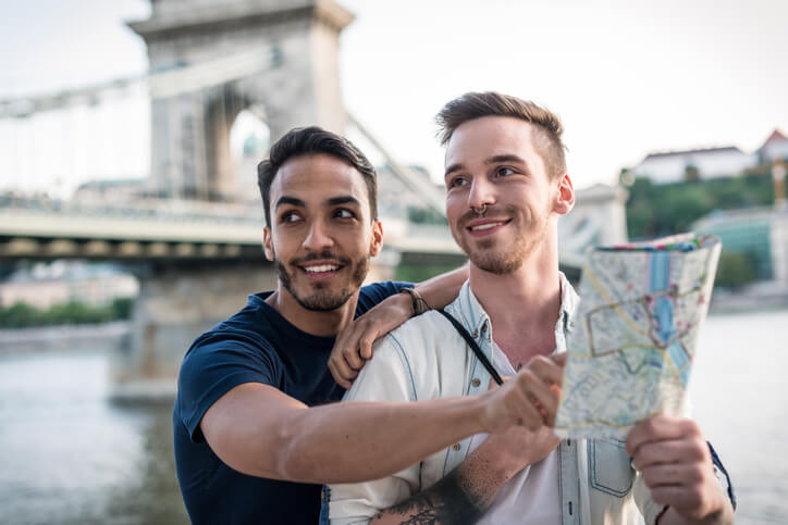 same sex couple holding passport travel abroad